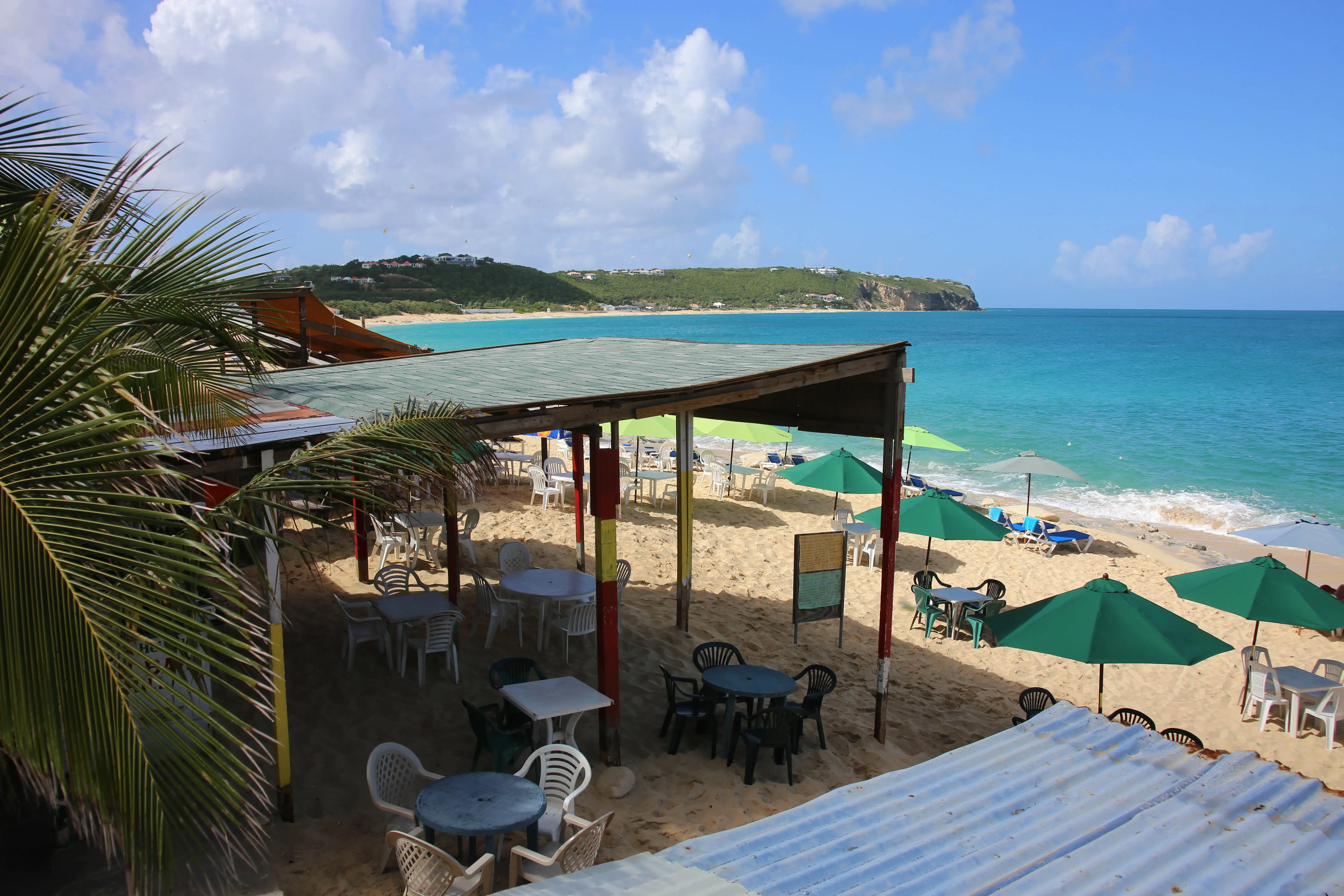 A small wooden beach bar shack standing at the edge of the sand at Baie Rouge