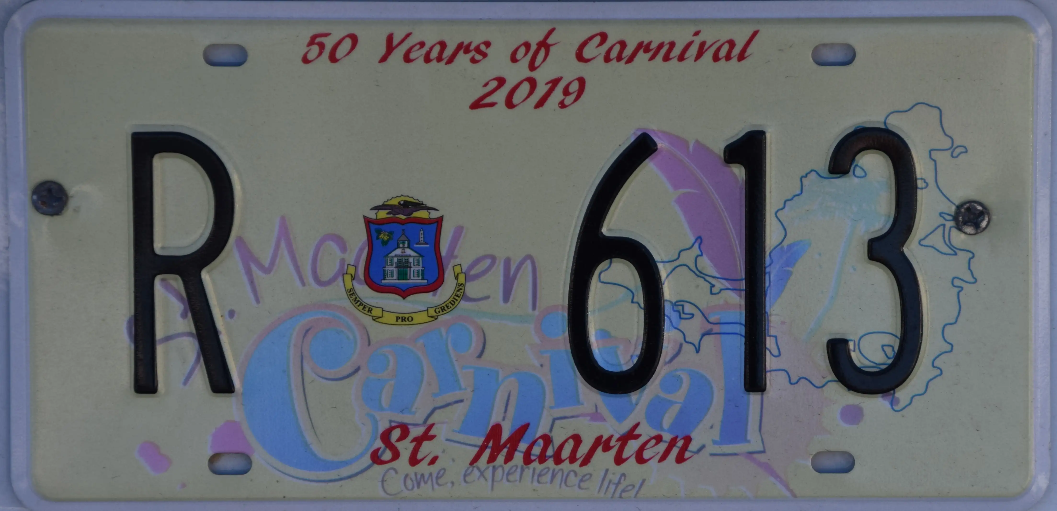 A Sint Maarten licence plate reading R 613 mounted on a vehicle, with the island coat of arms between the letter and the numbers