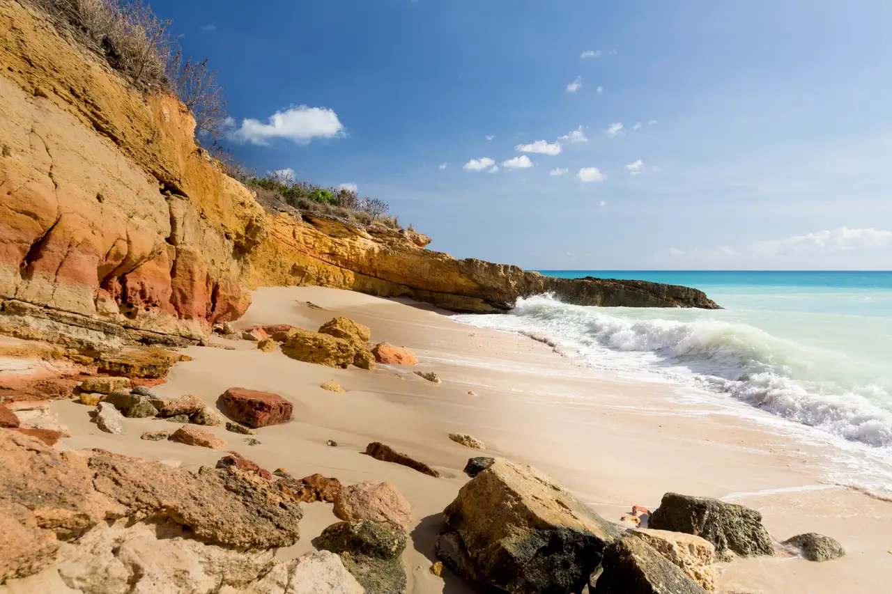 Sandstone cliffs framing a secluded stretch of Cupecoy Beach with turquoise water