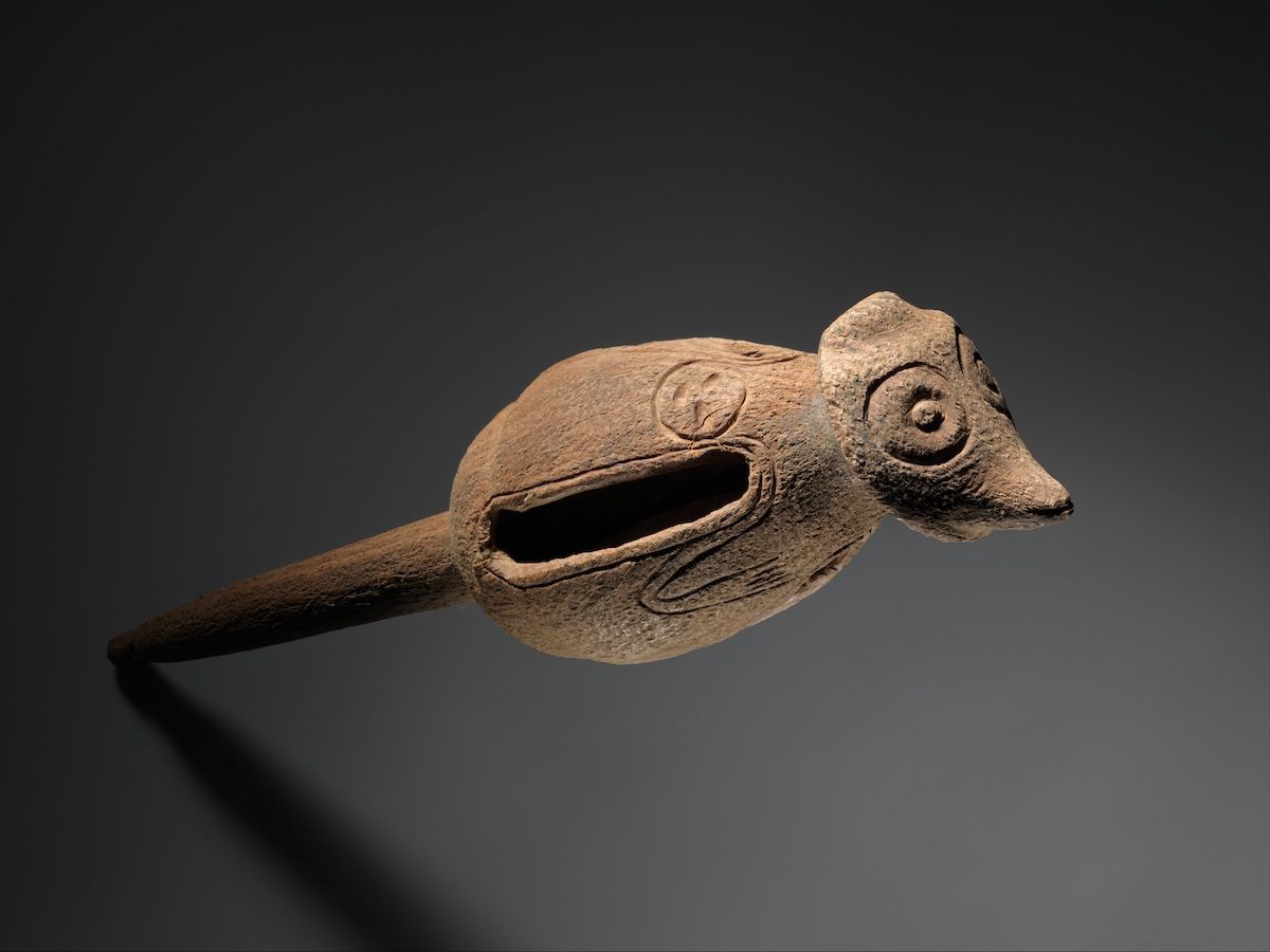 A ceramic rattle with a rounded body and incised decoration.
