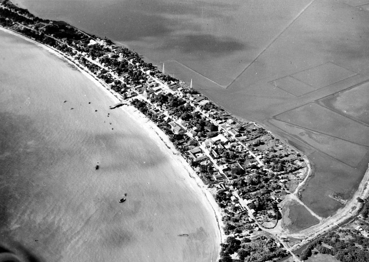 An aerial photograph of Great Bay showing Philipsburg on its sandbar between the bay and the rectangular grid of the salt pans.