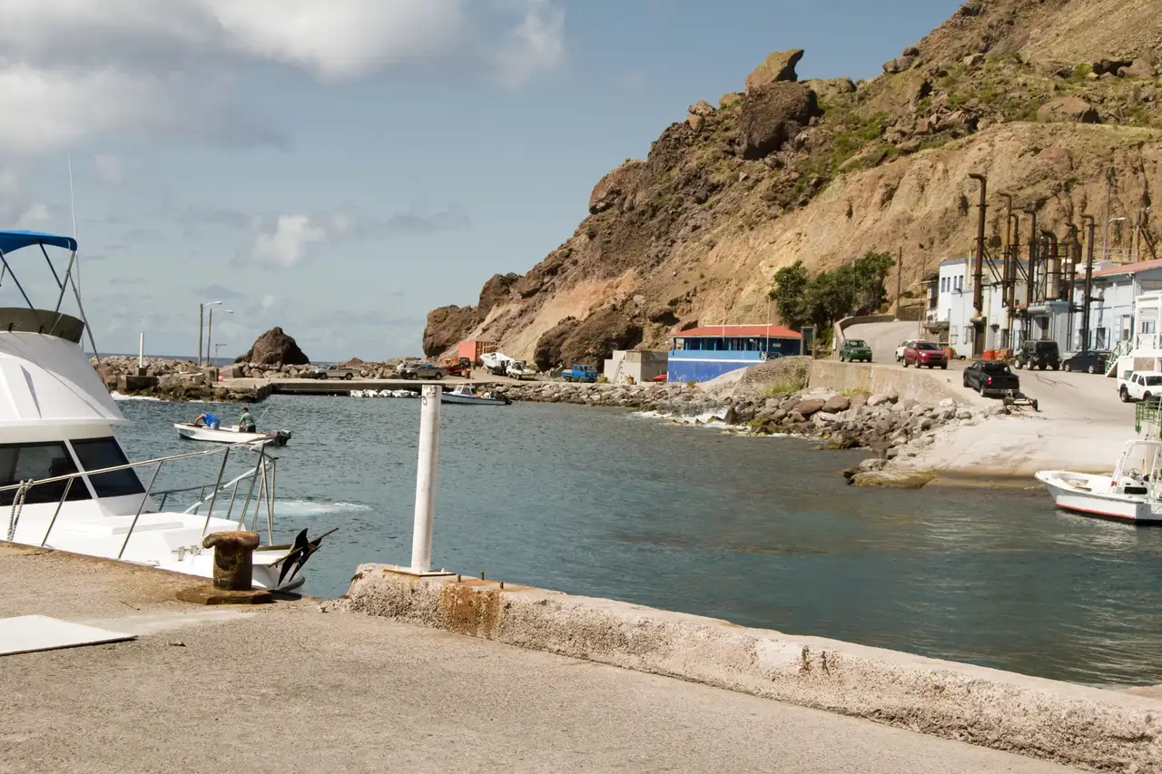 The small harbour at Fort Bay on Saba, a concrete pier and breakwater set against steep green cliffs dropping straight into the sea