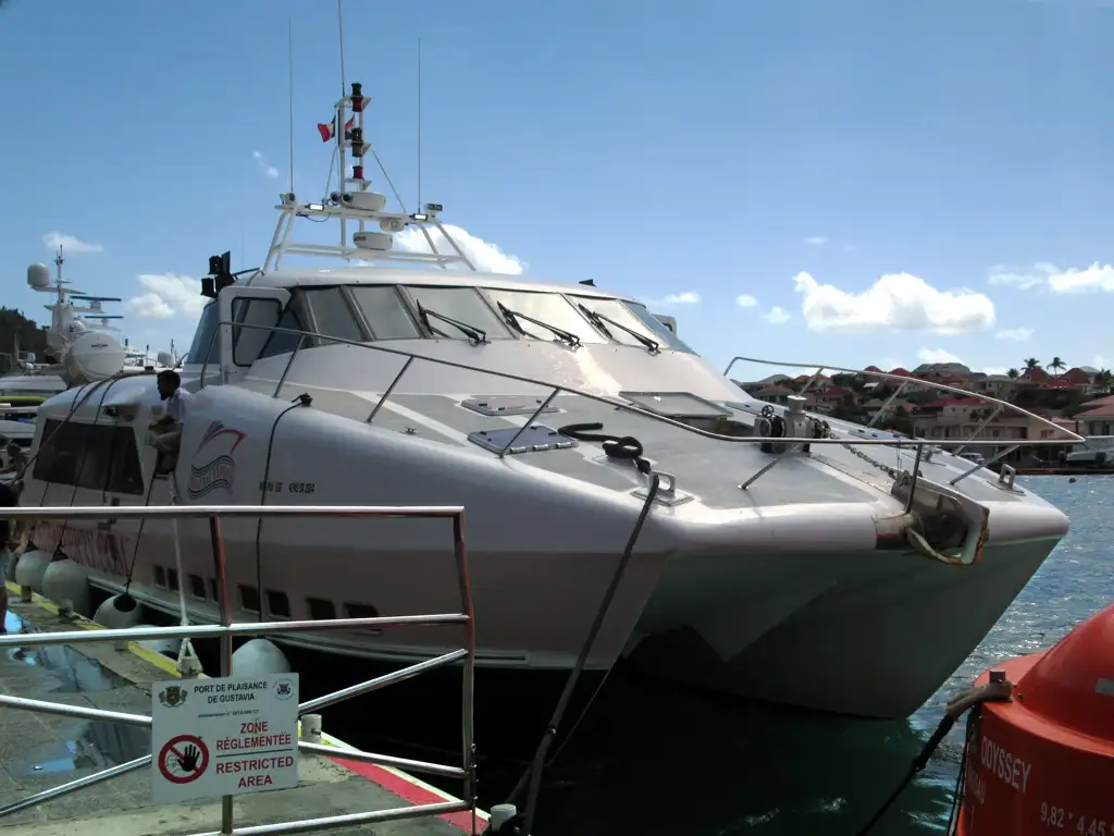 The Great Bay Express, a white and blue fast passenger ferry, tied up at the quay in Gustavia with its boarding ramp down