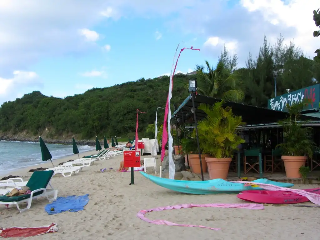 A small beach cafe standing on the sand at Friar's Bay with tables set out in front of it