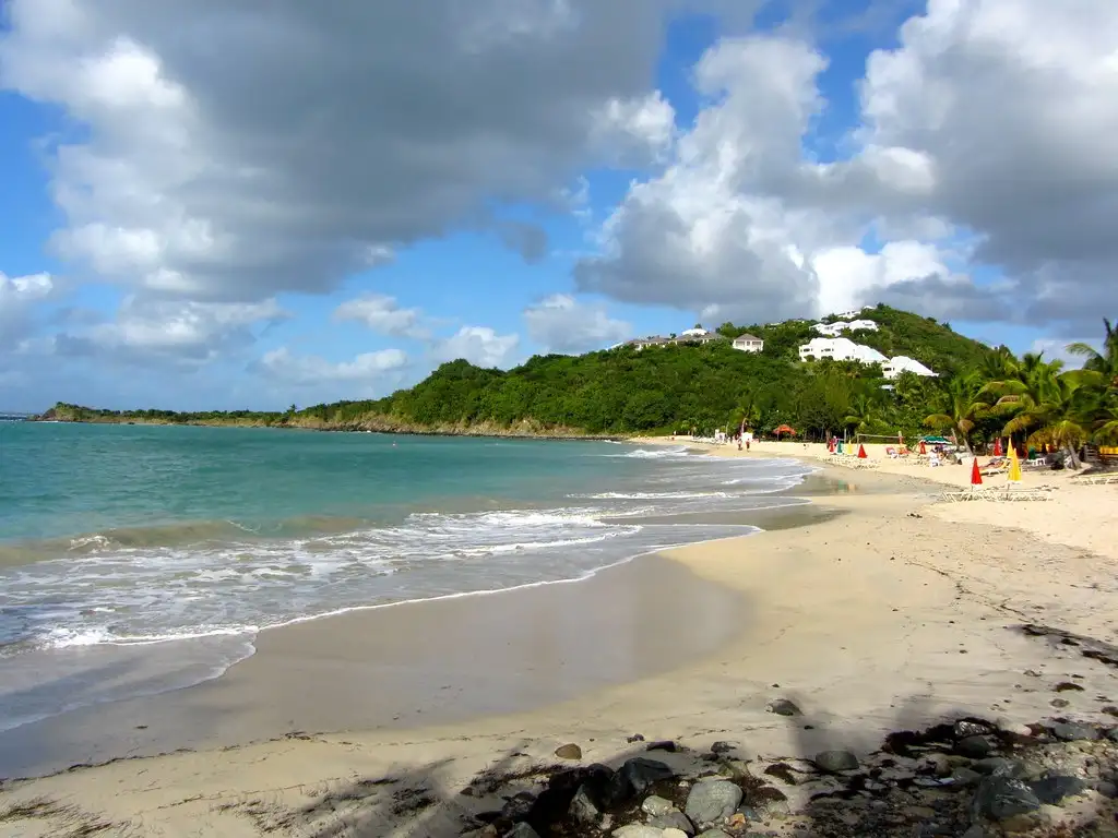 Calm water lapping the sand at Friar's Bay with barely any wave running up the beach