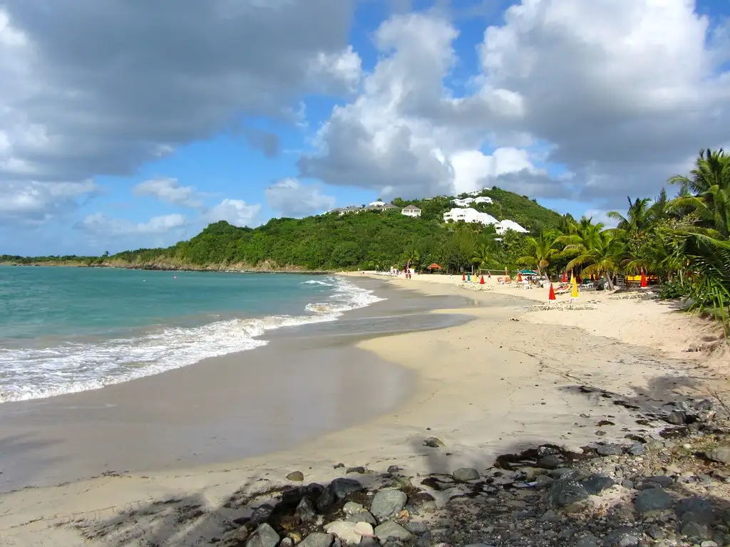 The sheltered crescent of Friar's Bay on the French side of Saint Martin, calm water meeting pale golden sand