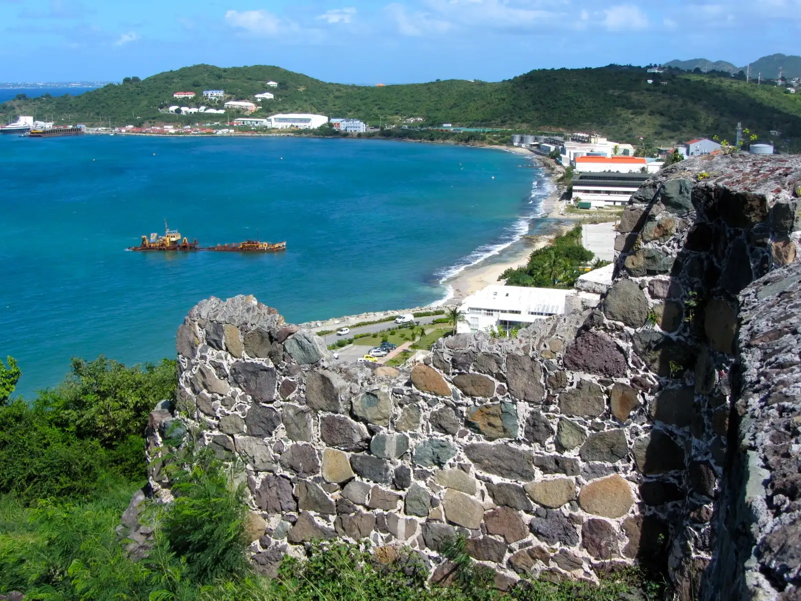 The bay north of Marigot seen over the stone walls of Fort Louis, water and shoreline below the fortification
