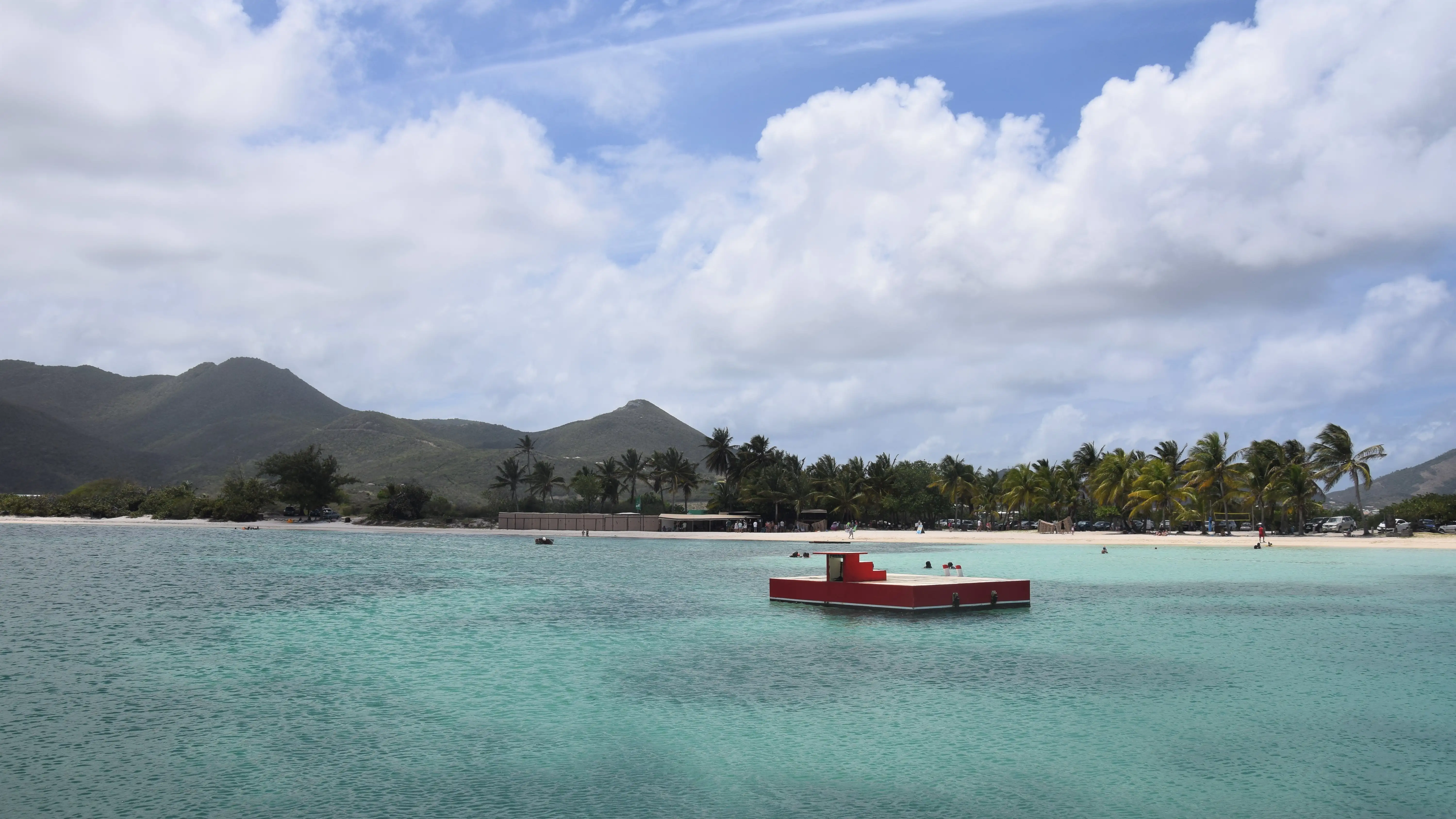 Wide view across Galion Bay with the line of the reef barrier visible offshore and flat water inside it
