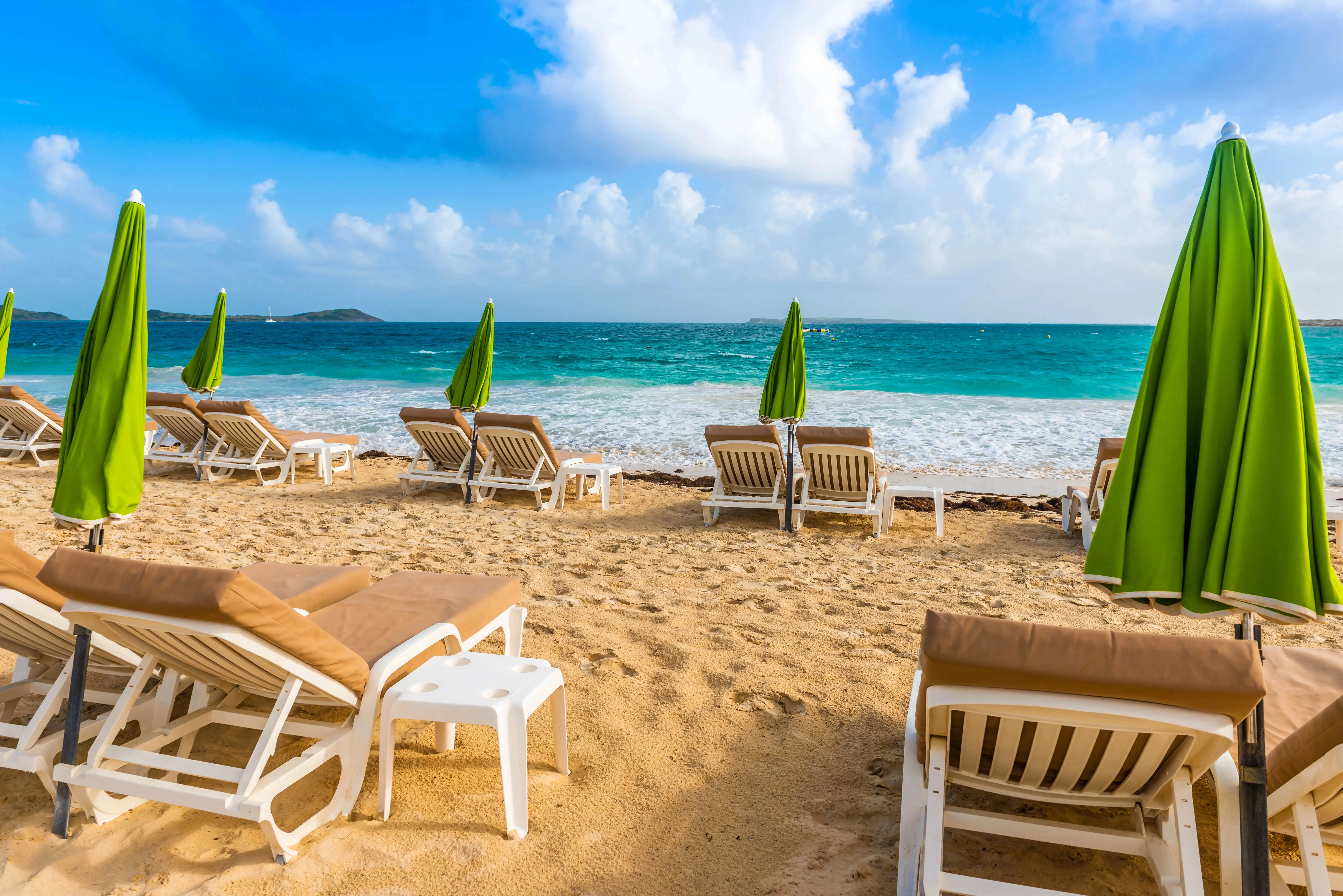 Closer view of beach loungers and umbrellas at Orient Bay with turquoise water