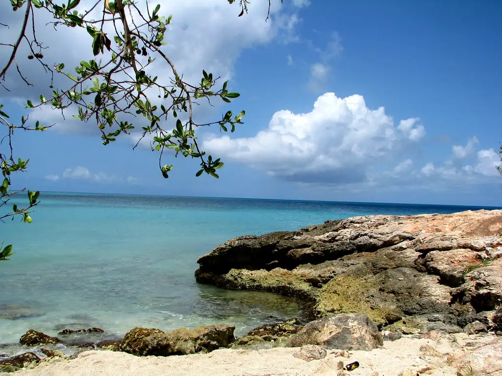 A rock outcrop at the end of the beach at Baie aux Prunes, shaped a little like a whale's head, with the sea beyond