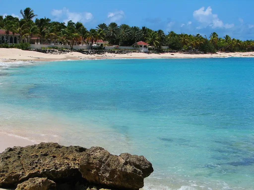 Villas standing on the slope above a quiet bay with aquamarine water below them