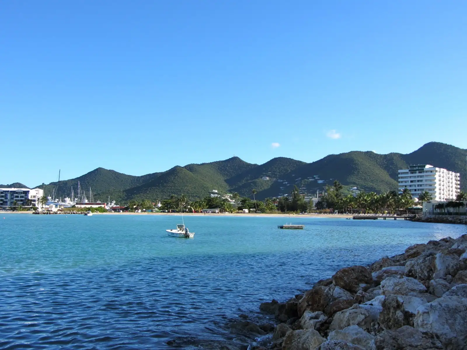 Sand and shallow water at Simpson Bay Beach with the shoreline running away into the distance