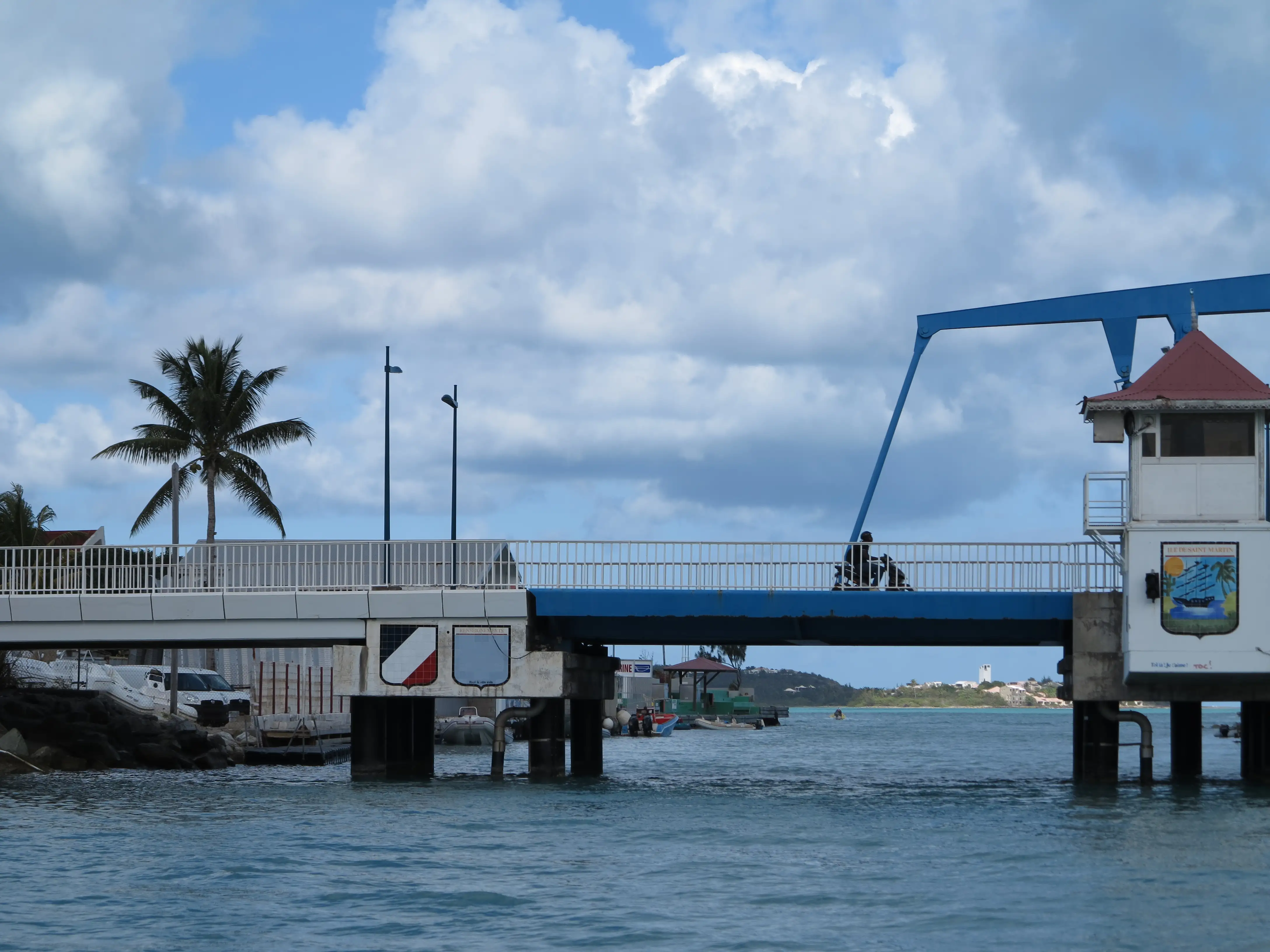 The small blue bascule drawbridge at the Simpson Bay lagoon channel, with a palm tree and lookout tower